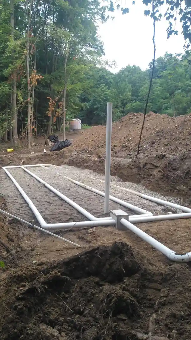 Excavated septic trench with distribution box and laterals set to grade