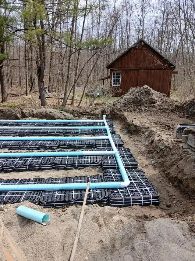 Septic leach field laterals and infiltration chambers laid out in a stone bed